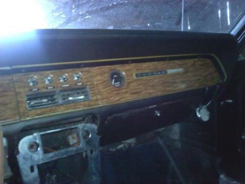 1968 Mercury Cougar - The interior of a 1968 Mercury Cougar shows its dashboard with woodgrain accents and a radio delete panel.