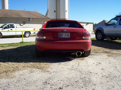 1989 Ford Bronco - The rear view of a red Honda Del Sol shows its exhaust pipe and license plate.