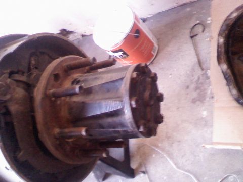 1996 Ford Bronco - Close-up of a rear axle hub assembly with a brake drum, showing 8 lug nuts and a metal drum.