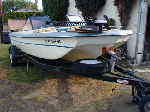 1968 Ford Mustang - A boat is parked on a trailer in a driveway, ready for transport.