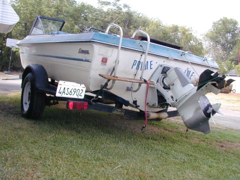 1968 Ford Mustang - A boat is parked on a grassy area, hitched to a trailer with a license plate.