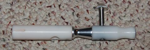1994 Ford Bronco - A close-up view of a white and chrome mechanical part with a knurled knob.