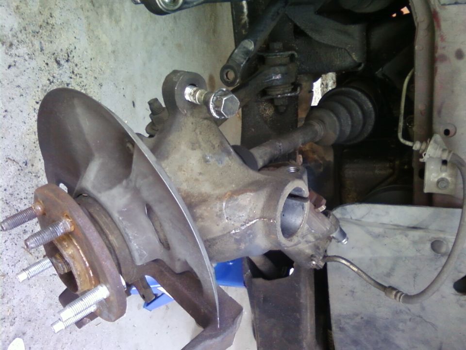 close-up of car's front suspension knuckle and brake rotor assembly