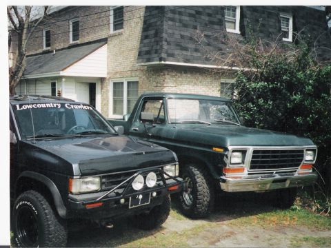 1979 Ford Bronco - A 1979 Ford Bronco is parked next to a black SUV, both vehicles are facing the front.