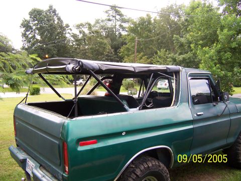 1979 Ford Bronco - Green 1979 Ford Bronco with its soft top removed, seen from the rear quarter angle.
