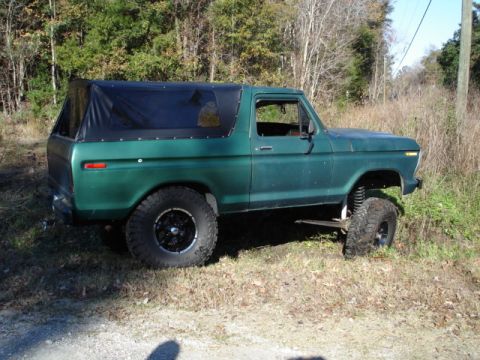 1979 Ford Bronco - This 1979 Ford Bronco features a green exterior, a black soft top, and a lifted suspension, viewed from the side.