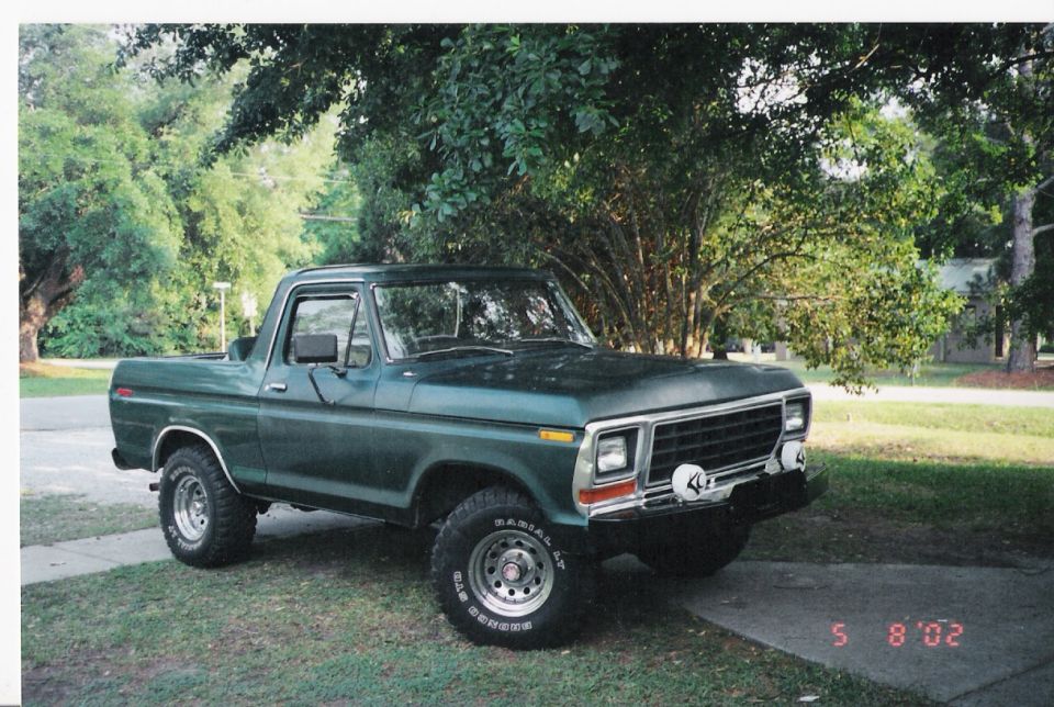 Green Ford Bronco parked outside on a sunny day