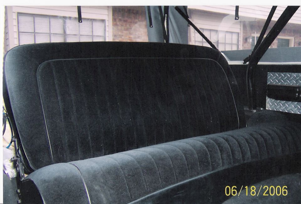 Back seat and interior of a vehicle, with diamond plate trim visible on the right