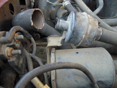 1992 Ford Bronco - A close-up view of various engine components, including hoses and a filter housing.