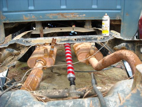 1979 Ford F-150 - Pickup truck undercarriage with dual exhaust system and a can of lubricant.