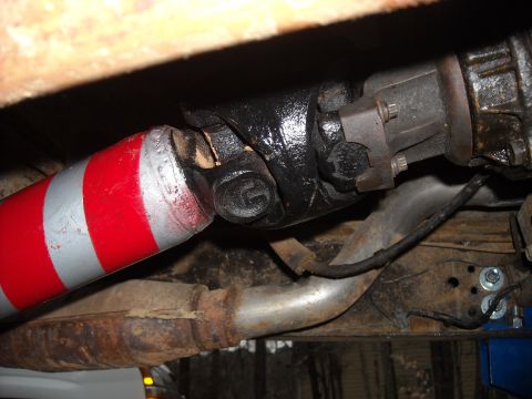 1979 Ford F-150 - Close-up view of a vehicle's driveshaft, distinctive red and silver stripes and a universal joint connection.