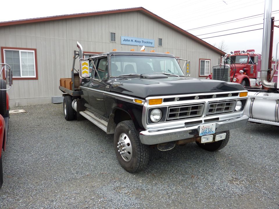 Black flatbed truck with chrome grille and dual rear wheels. License plate reads DEESHL