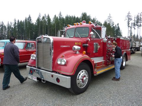 1981 Kenworth W900A - A red Kenworth fire truck is parked outdoors with a person inspecting its side panel.