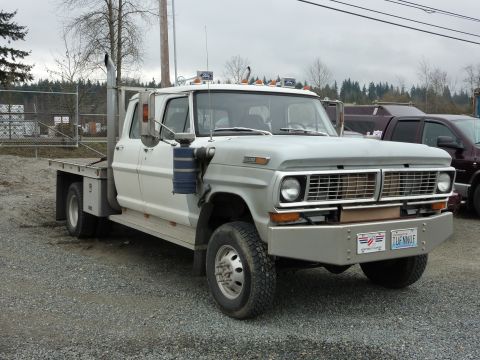 1981 Kenworth W900A - This Ford F-Series truck features a flatbed and dual rear wheels, with a prominent chrome bumper.