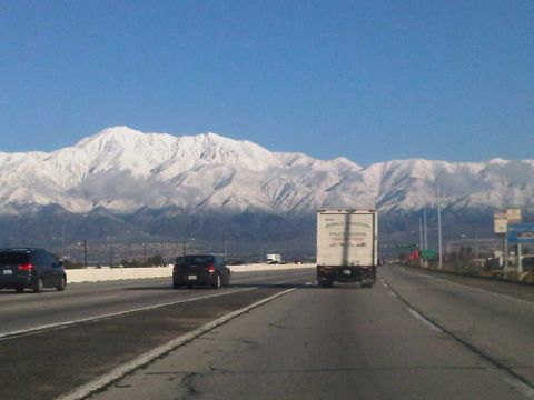 1986 Ford Bronco - Driving on a highway with snow-capped mountains visible in the distance.