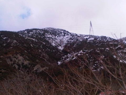 1986 Ford Bronco - A snowy mountain landscape with power lines and a distant tower is seen in Lytle Creek.