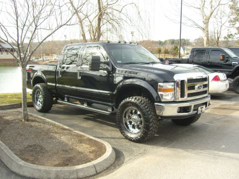 2007 Ford Mustang - This black Ford F-Series Super Duty pickup truck features a prominent chrome grille and large off-road tires.