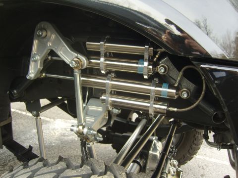 2007 Ford Mustang - Close-up view of a heavily modified vehicle suspension system with multiple shock absorbers.