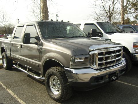 2007 Ford Mustang - Gray Ford F-250 Super Duty pickup truck in a parking lot with another truck behind it.
