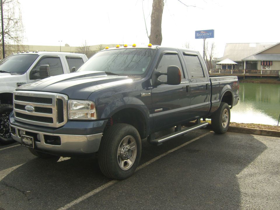 Dark blue crew cab pickup truck, 3/4 front view. License plate visible