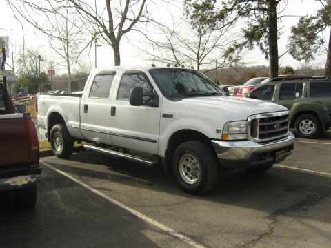 2007 Ford Mustang - White Ford F-250 Super Duty pickup truck parked in a lot with other vehicles.