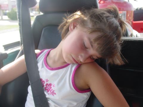 1973 Ford Bronco - A young girl sleeps soundly while riding in a vehicle.