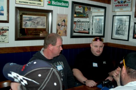 2007 Ford Mustang - People gathered indoors, with decor including beer advertisements and framed artwork on the walls.