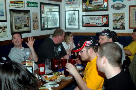 2007 Ford Mustang - A group of people are seated at tables in a restaurant, with various decorations adorning the walls.