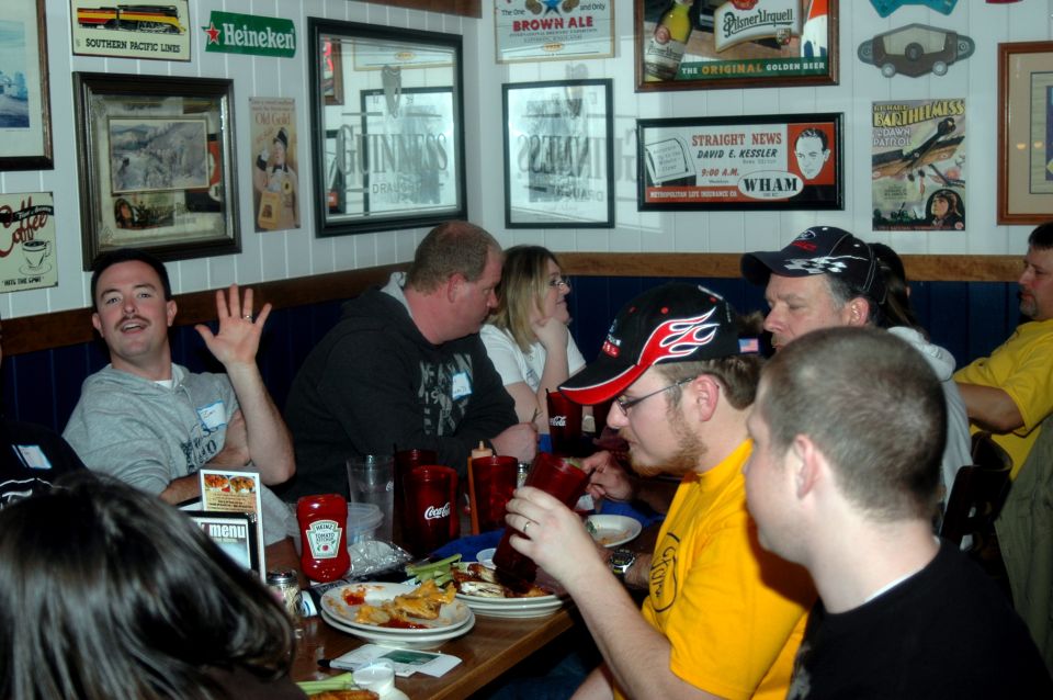 People gathered around tables in a restaurant with decorations on the walls