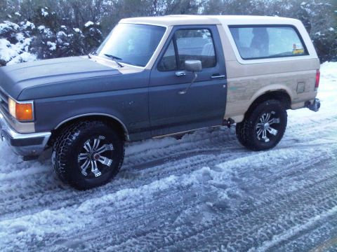 1986 Ford Bronco - This Ford Bronco is parked on a snow-covered road, showing off its two-tone paint scheme.