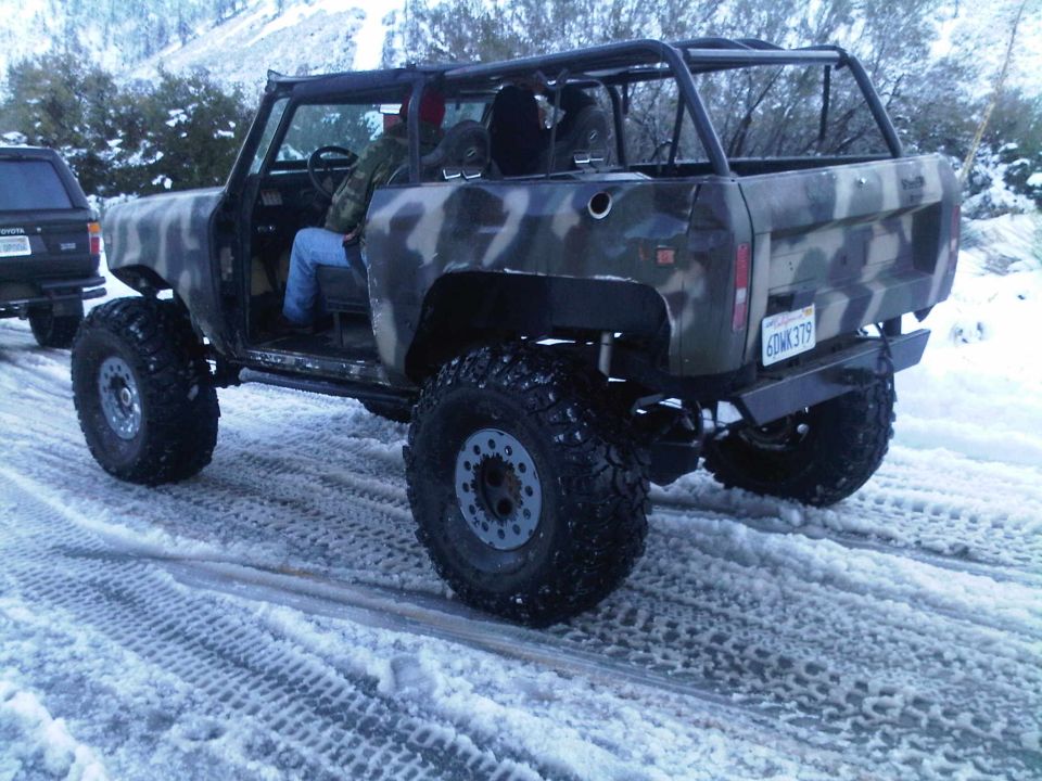 Camouflaged off-road vehicle with large tires on a snowy road