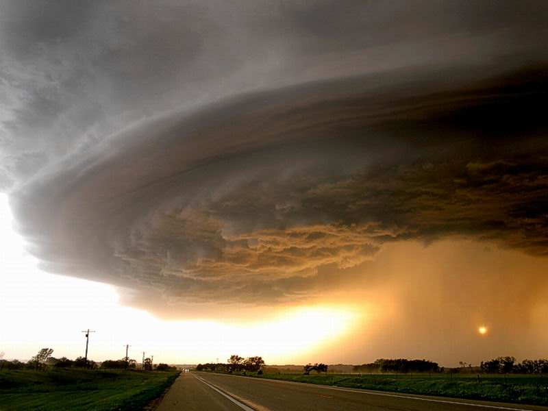 Supercell thunderstorm over a rural road at sunset