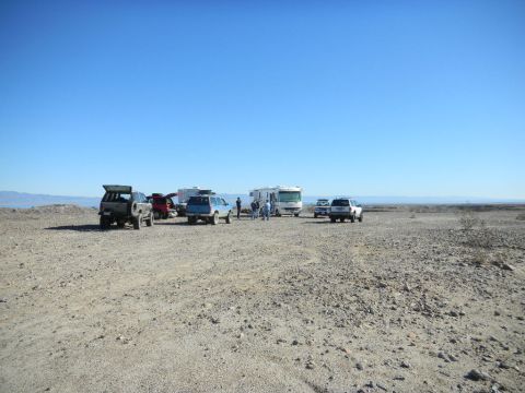 1997 Ford Ranger - A collection of vehicles and recreational vehicles are gathered in a wide-open desert area under a bright blue sky.