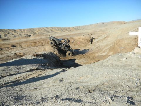 1997 Ford Ranger - A modified off-road vehicle navigates a challenging dirt terrain under a clear sky.