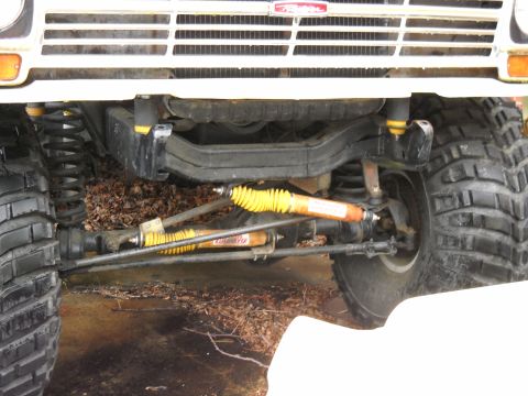 1982 Ford Bronco - Close-up of the front suspension and grille of a 1982 Ford Bronco.