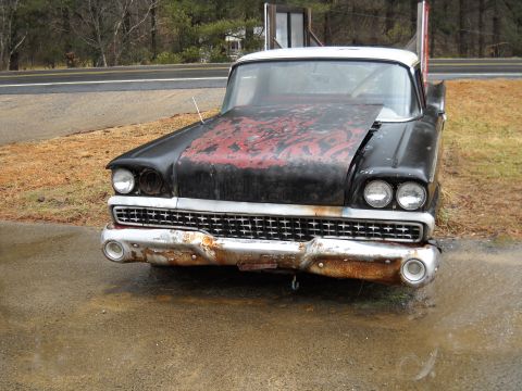 1982 Ford Bronco - A vintage car with a weathered exterior sits parked on the side of the road.