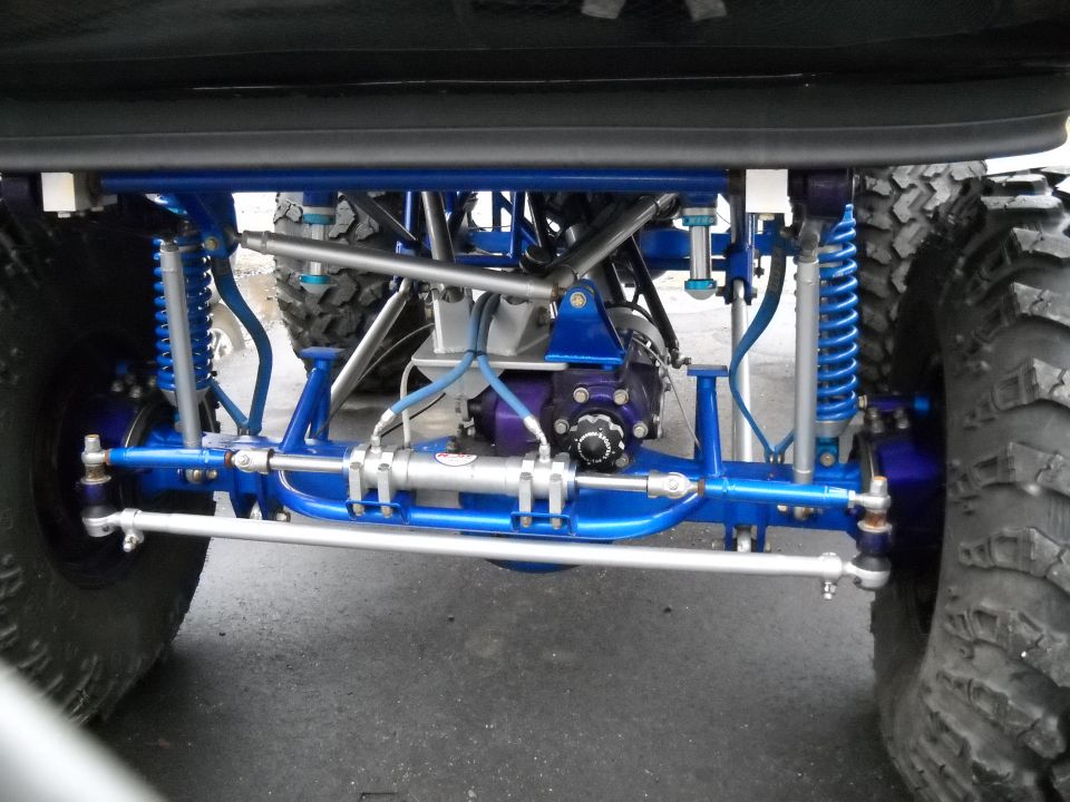 Modified front axle with blue suspension components and large tires