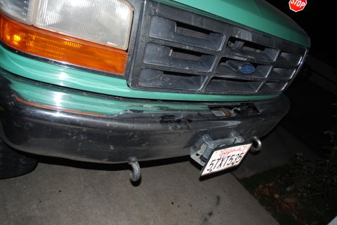 1996 Ford Bronco - The front grille and bumper of a green Ford truck are visible, with a California license plate attached.