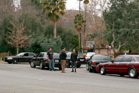 1992 Ford Crown Victoria - A group of Ford Crown Victorias, including a red one with custom wheels, are gathered in a residential area.