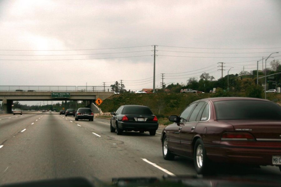 Maroon 1992 Ford Crown Victoria driving on highway, seen from rear