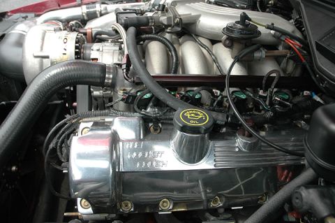 1992 Ford Crown Victoria - Close-up view of a car's engine bay, showing polished chrome valve covers and intricate mechanical parts.