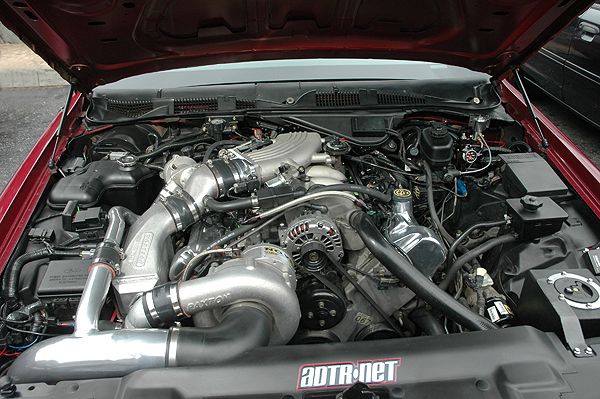 Red 1992 Ford Crown Victoria engine bay with twin turbochargers and custom intake piping