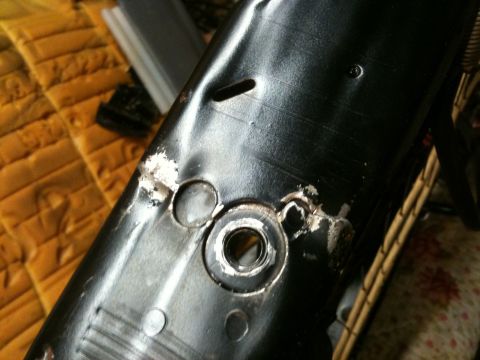 1995 Ford Bronco - Close-up of a damaged black metal component, possibly from a seat, showing signs of repair and wear.
