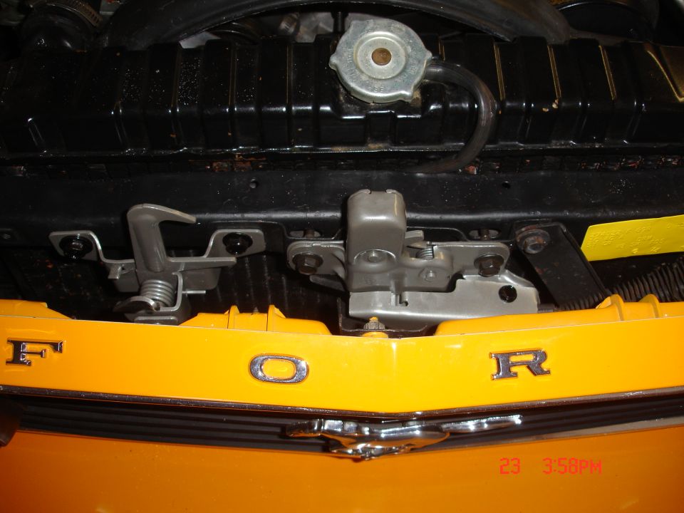 Yellow Ford grille with chrome emblem and hood latch mechanism