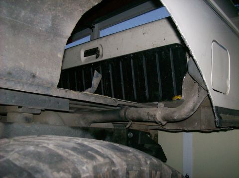1989 Ford Bronco - A close-up view of a vehicle's undercarriage reveals the rear tire and exhaust system.