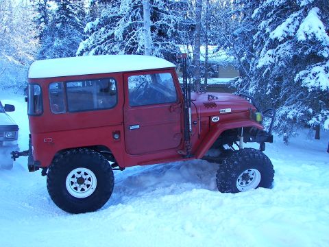 1990 Chevrolet Suburban - This red off-road vehicle with a white hardtop is parked in the snow, with a 4WD badge visible on the fender.