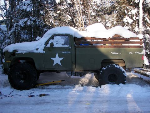 1990 Chevrolet Suburban - This pickup truck, possibly from the 1980s, is parked outside in the snow with a military-style star decal.