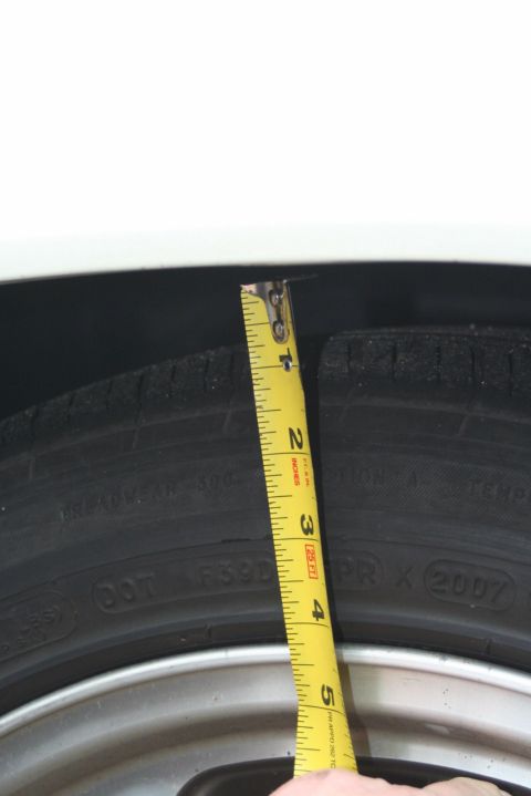 1976 Ford Ranchero - Measuring the clearance between the tire and the fender with a tape measure.