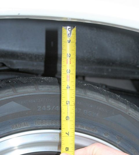 1976 Ford Ranchero - A tape measure is used to check the clearance between a tire and the vehicle's fender.