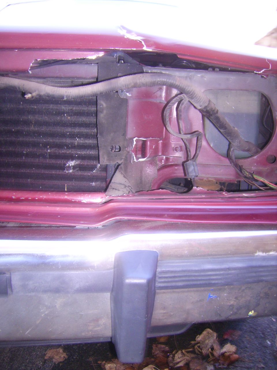 Red car front end damage, showing radiator and bumper
